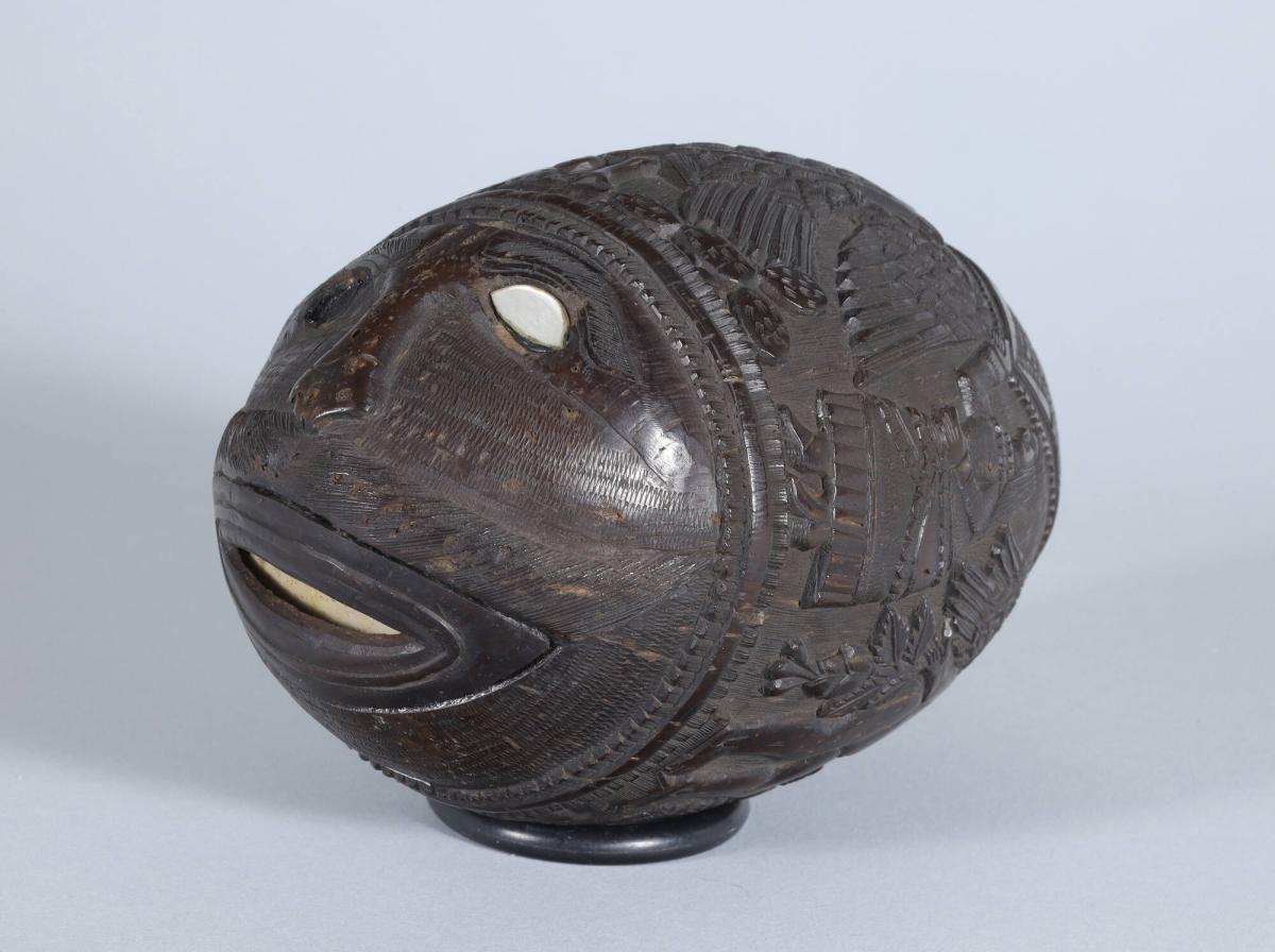 Carved Coconut Bank with Figures and a Face